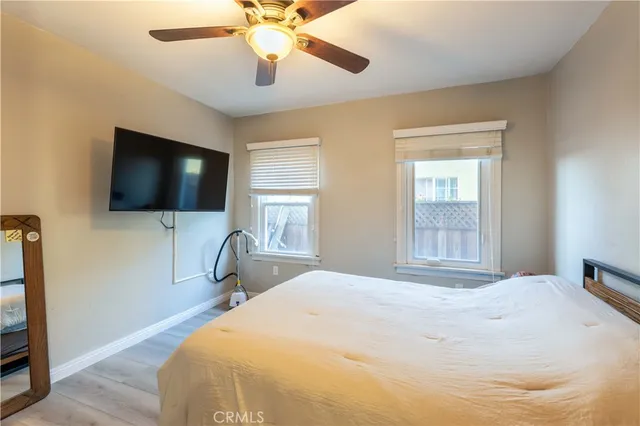 a bedroom with a bed and a flat tv screen on dresser