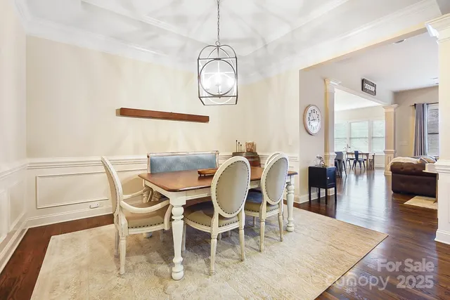 a dining room with wooden floor a glass table and chairs