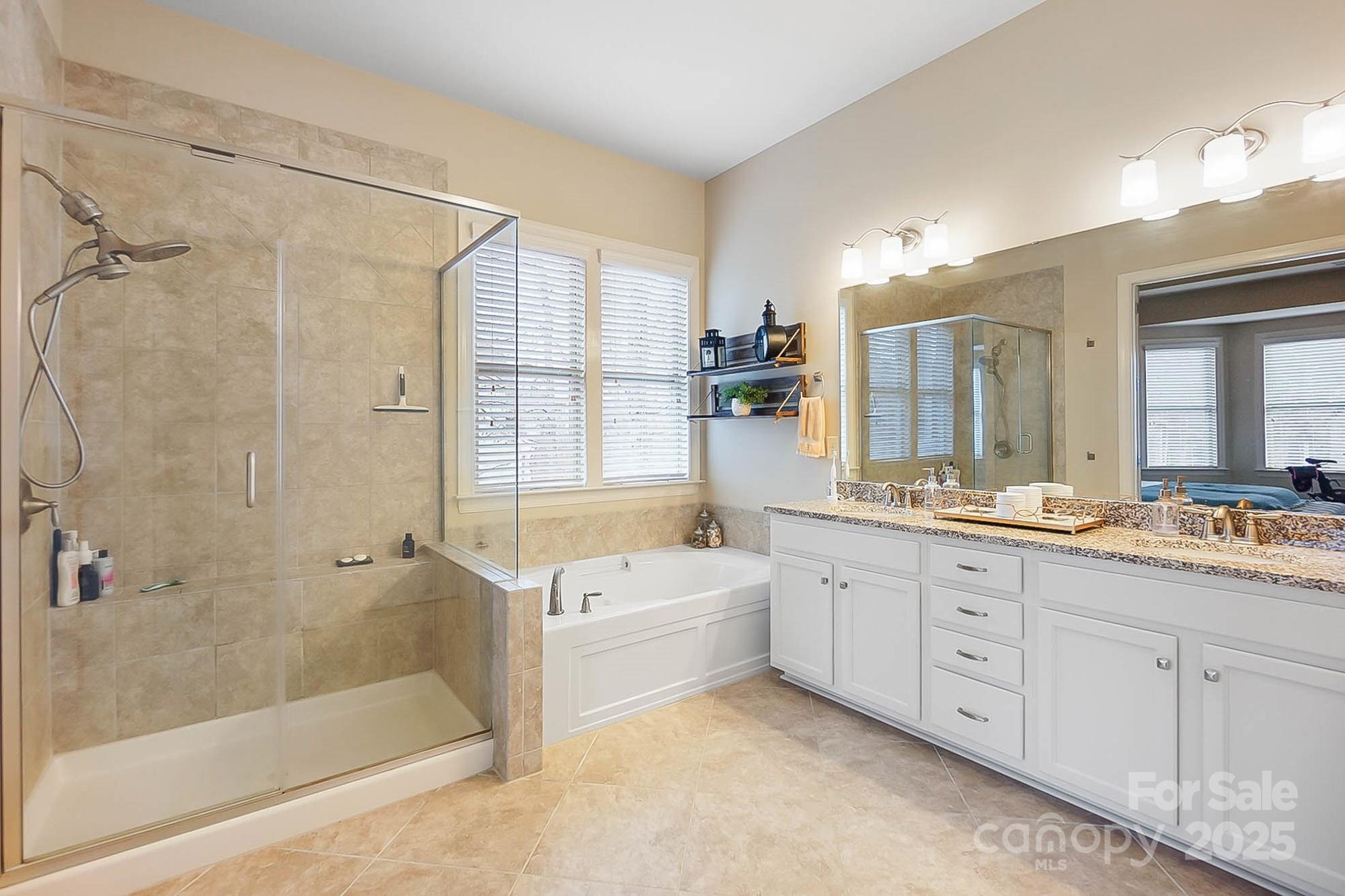 1419 Vickery Drive Matthews, NC 28104 - Photo 24 of 48 a bathroom with a granite countertop bathtub a sink and a shower