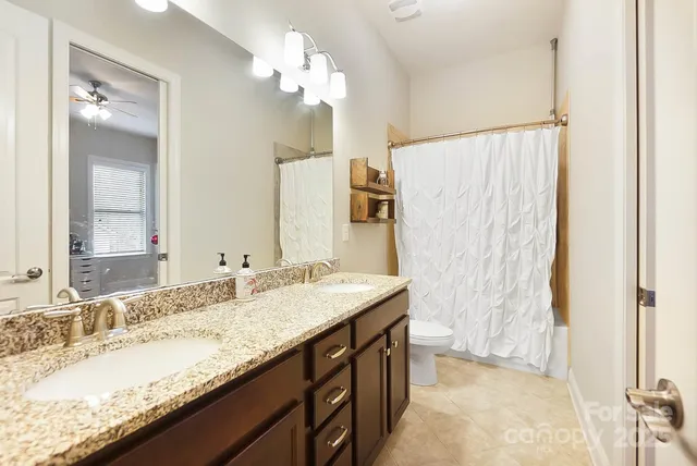 a bathroom with a granite countertop sink a mirror and a shower
