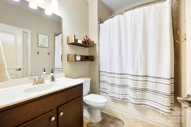 a bathroom with a sink a toilet and shower curtain