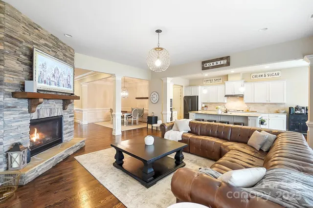 a living room with furniture kitchen view and a fireplace