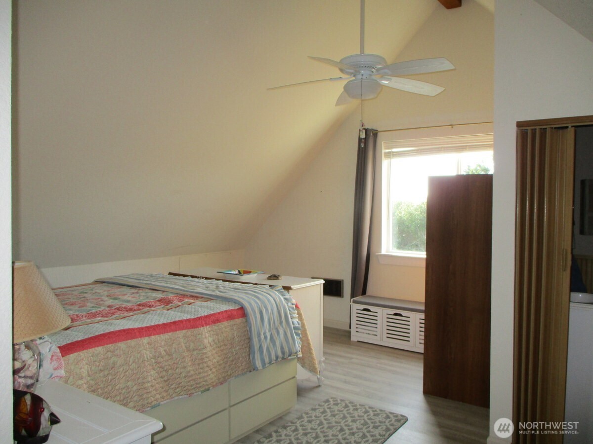 369 North Razor Clam Drive Southwest Ocean Shores, WA 98569 - Photo 14 of 27 a bedroom with a bed and a chandelier