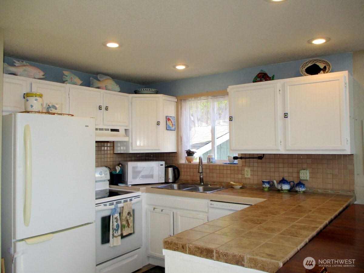 369 North Razor Clam Drive Southwest Ocean Shores, WA 98569 - Photo 8 of 27 a kitchen with stainless steel appliances granite countertop a sink refrigerator and white cabinets