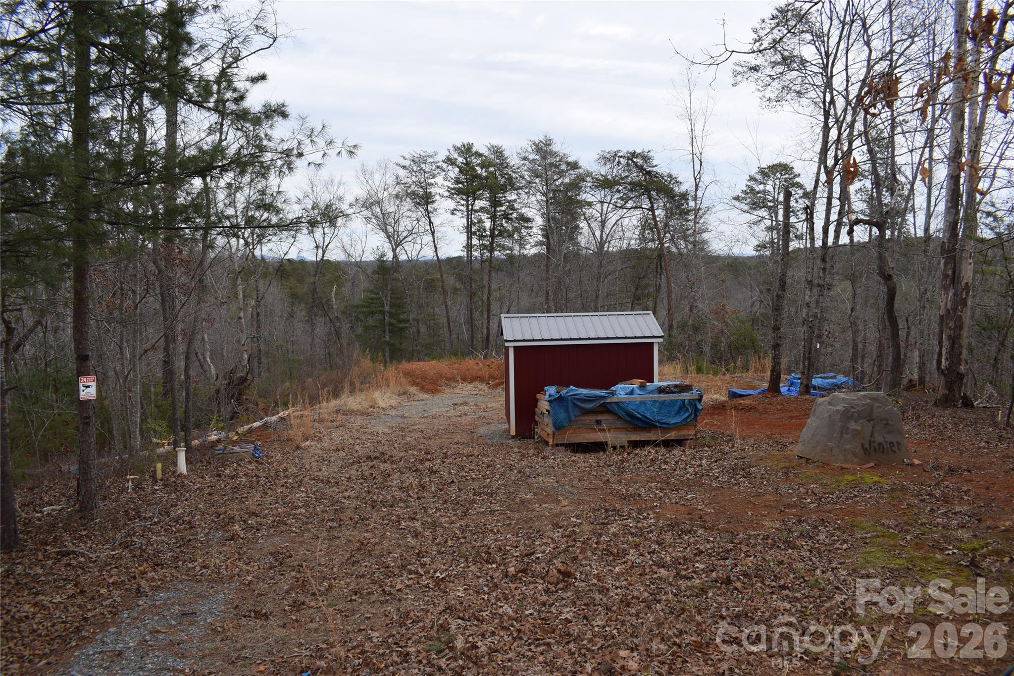 172 Winter Lane Mill Spring, NC 28756 - Photo 3 of 20 a wooden bench sitting in the middle of a yard
