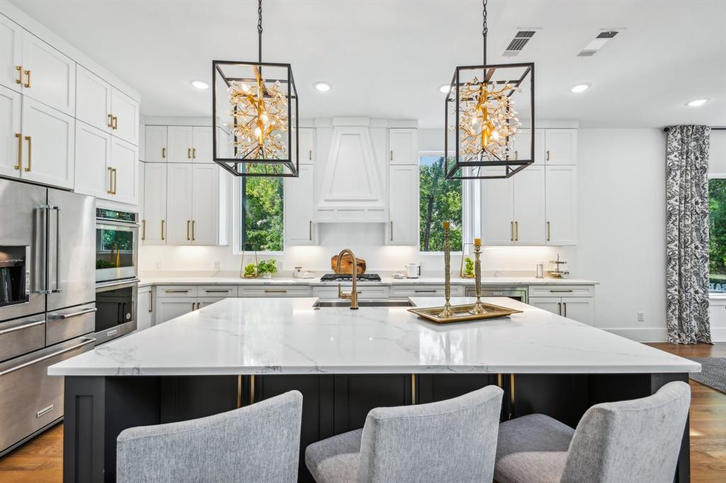 478 Polly Road Sunnyvale, TX 75182 - Photo 13 of 40 Kitchen with a chandelier, stainless steel appliances, a center island with sink, wood finished floors, and recessed lighting