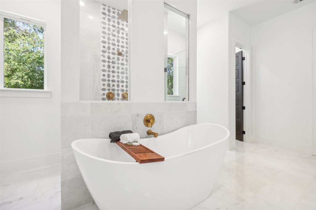 478 Polly Road Sunnyvale, TX 75182 - Photo 19 of 40 Bathroom with marble tiled flooring, a freestanding bath, and tile walls