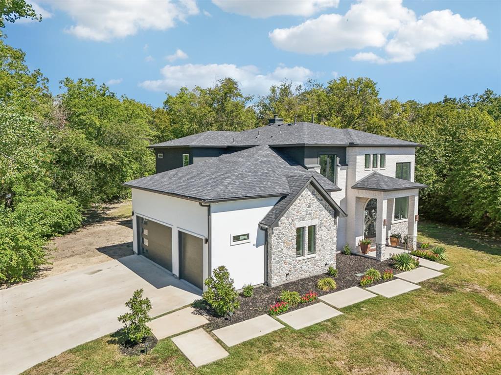 478 Polly Road Sunnyvale, TX 75182 - Photo 5 of 40 View of front of house featuring driveway, stone siding, an attached garage, stucco siding, and a front lawn