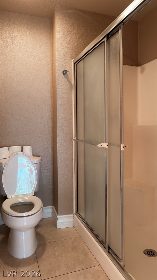210 East Flamingo Road, Unit 112 Las Vegas, NV 89169 - Photo 17 of 59 Neutral tiled flooring complements a walk-in shower with sliding glass doors in this tidy bathroom.