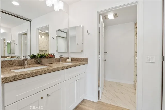 a bathroom with a granite countertop sink and a mirror