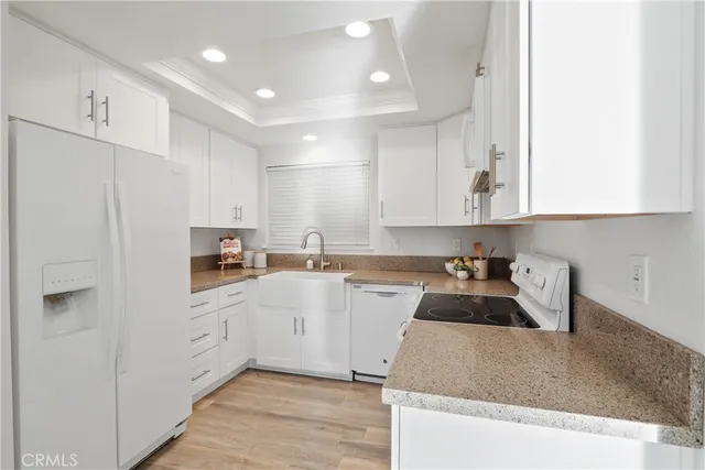a kitchen with white cabinets and sink