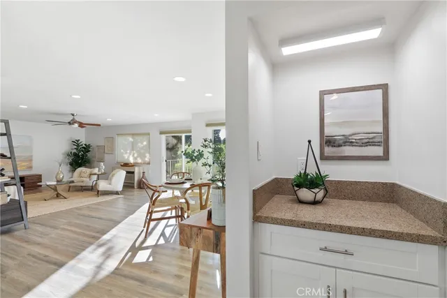 a living room with furniture potted plant and kitchen view