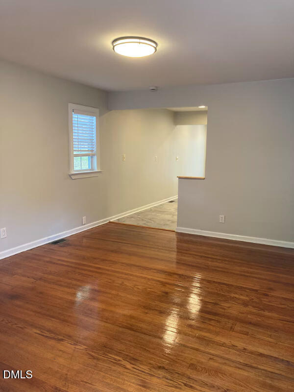 1505 Woodland Road Garner, NC 27529 - Photo 4 of 19 a view of an empty room with wooden floor and a window
