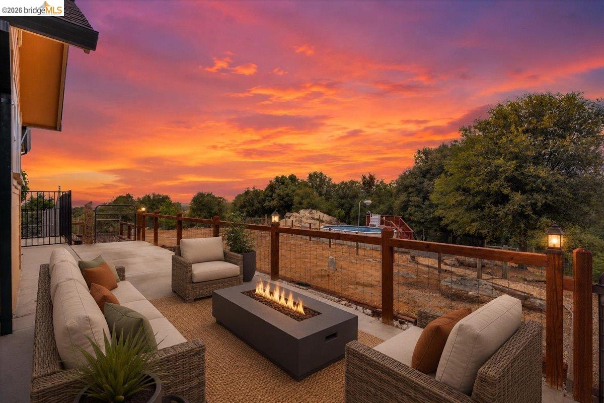 18180 Robin Ridge Road Sonora, CA 95370 - Photo 62 of 88 Expansive outdoor patio featuring a built-in fire pit, concrete flooring, and a robust wood and wire railing system