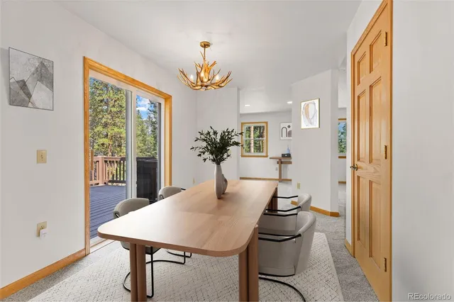 a view of a dining room with furniture and a chandelier