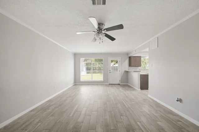 a view of a room with a ceiling fan hardwood floor and a window