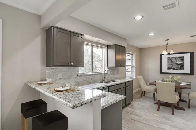 a kitchen with a sink cabinets and wooden floor