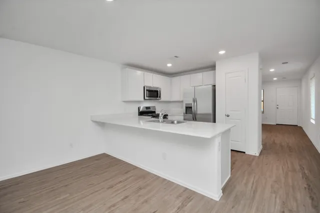 a view of kitchen with wooden floor and electronic appliances