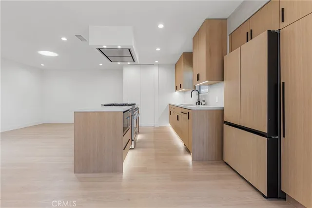 a kitchen with stainless steel appliances granite countertop a refrigerator a sink and a stove