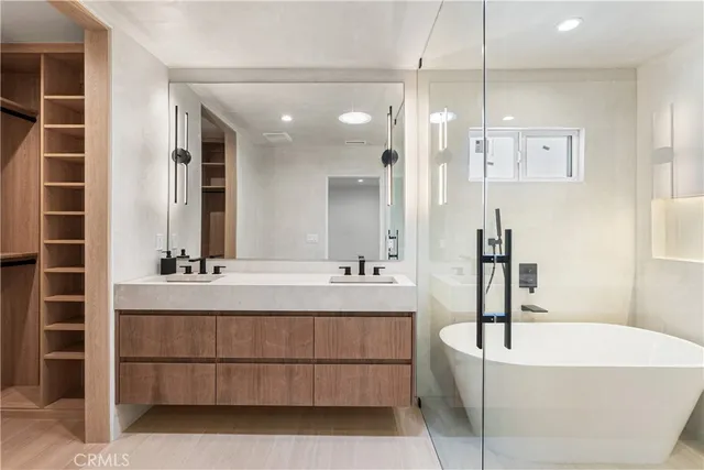 a bathroom with a tub a sink and mirrors