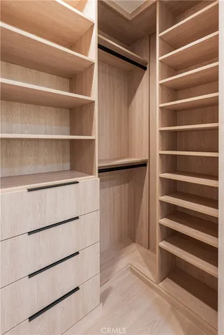 a view of walk in closet with empty racks