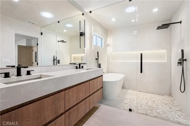 a bathroom with a double vanity sink a toilet and a mirror