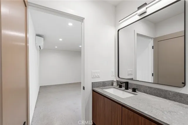 a bathroom with a granite countertop sink and a mirror