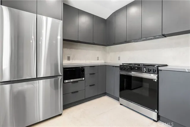 a kitchen with stainless steel appliances granite countertop a refrigerator sink and stove