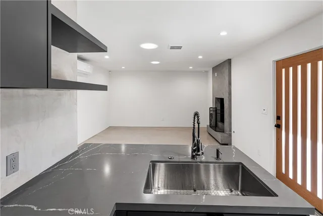 a kitchen with stainless steel appliances granite countertop a sink a stove and a refrigerator