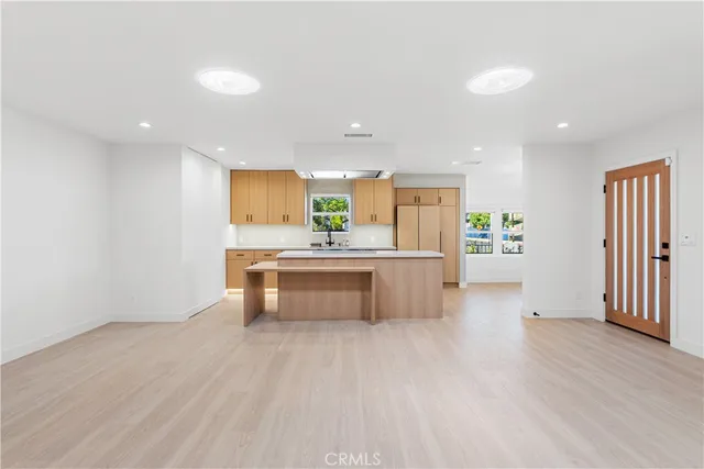 a large kitchen with a wooden floor and stainless steel appliances