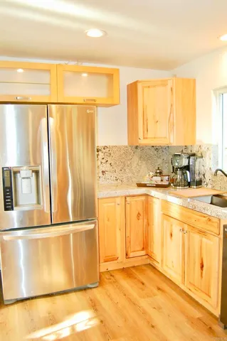 a view of a kitchen with wooden floor and stainless steel appliances