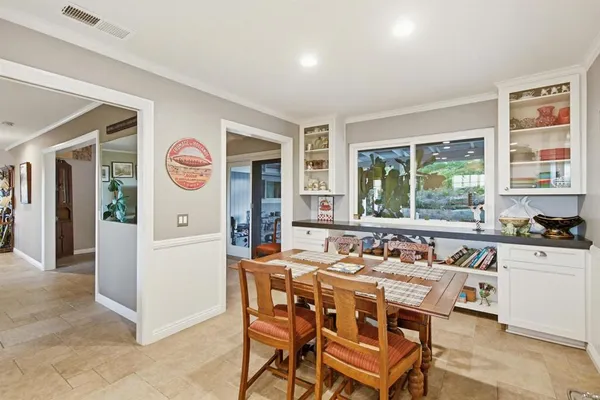 a kitchen with stainless steel appliances granite countertop a stove a microwave a dining table and chairs