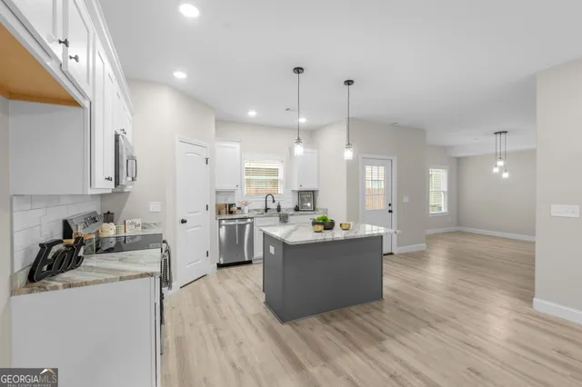 a kitchen with a sink stainless steel appliances and white cabinets