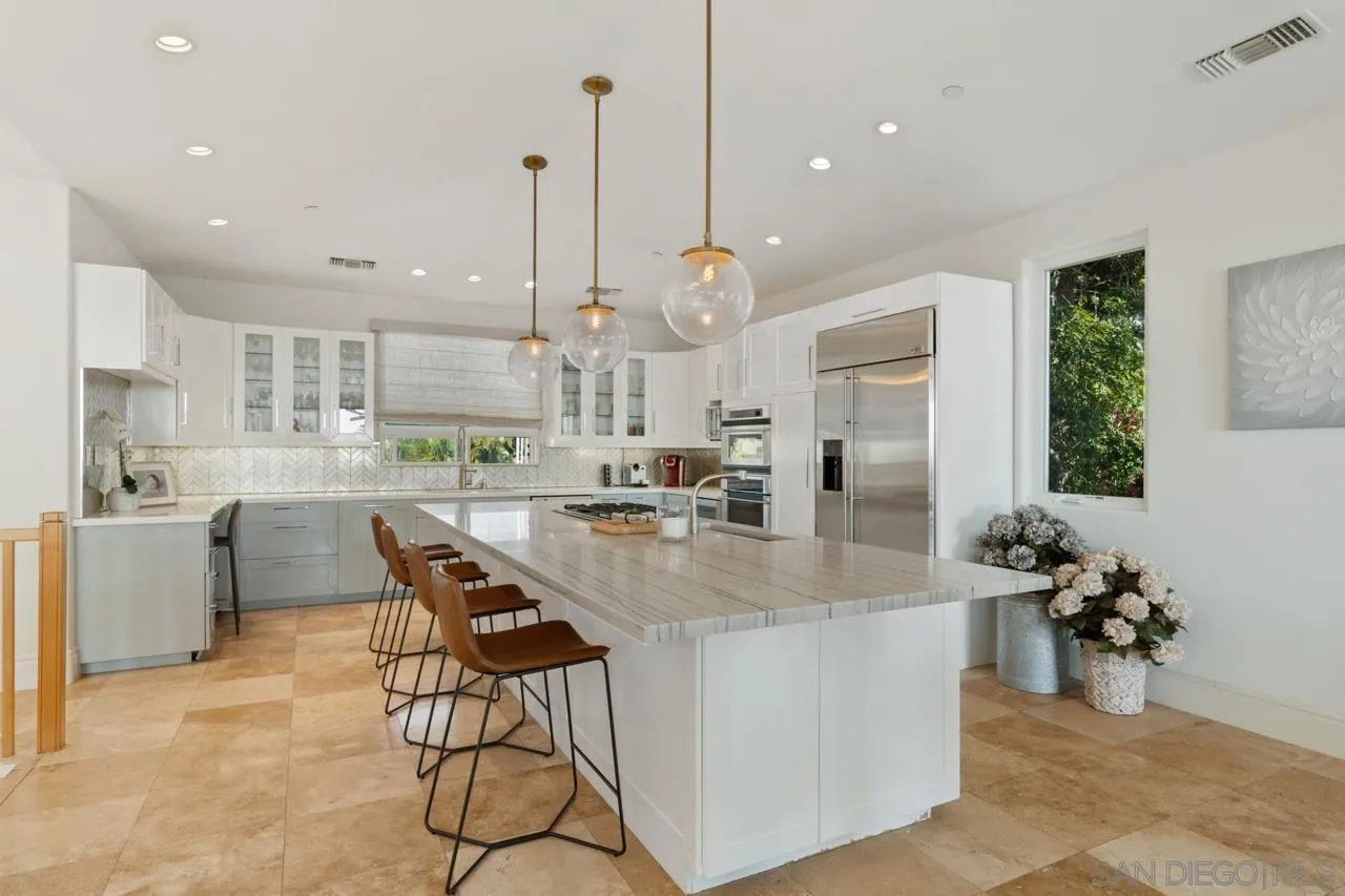 733 Stratford Drive Encinitas, CA 92024 - Photo 17 of 46 a kitchen with stainless steel appliances kitchen island granite countertop a table chairs and a sink