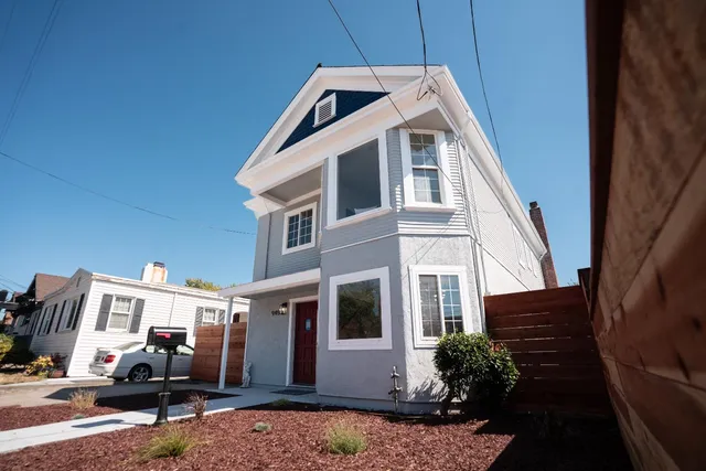 a view of a white house with many windows and potted plants
