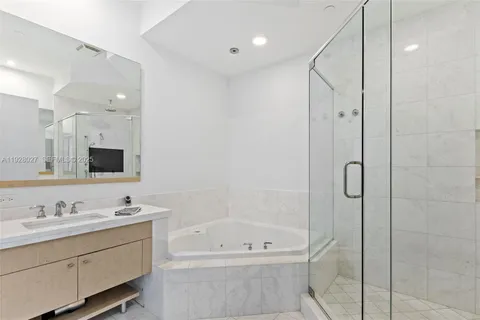 a bathroom with a tub a sink shower and mirror