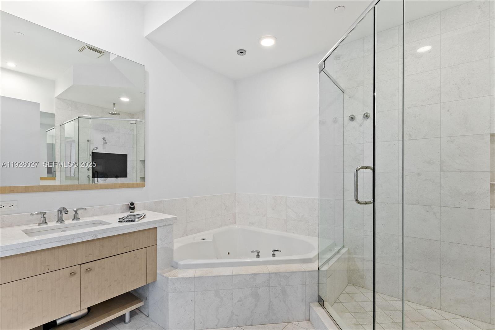 900 Brickell Key Boulevard, Unit 2002 Miami, FL 33131 - Photo 11 of 28 a bathroom with a tub a sink shower and mirror