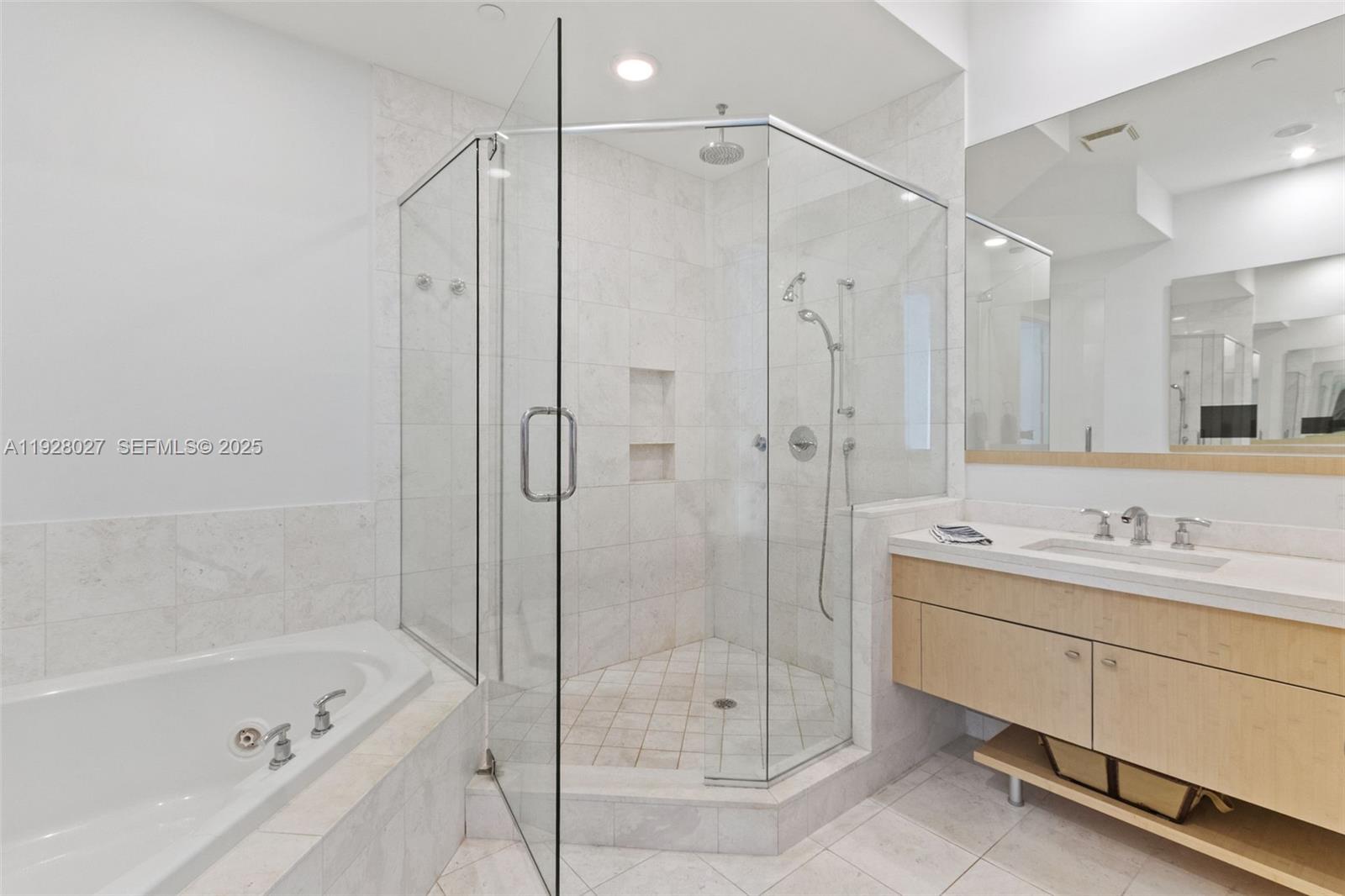 900 Brickell Key Boulevard, Unit 2002 Miami, FL 33131 - Photo 12 of 28 a bathroom with a shower sink vanity and mirror