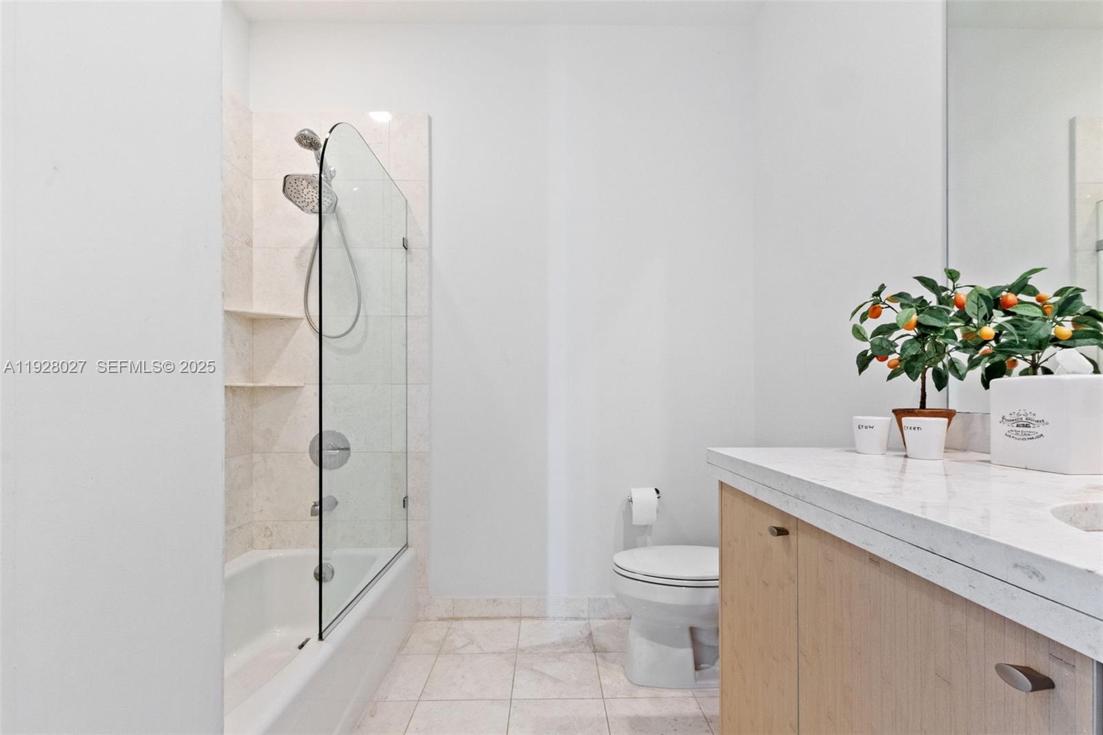 900 Brickell Key Boulevard, Unit 2002 Miami, FL 33131 - Photo 14 of 28 a bathroom with a granite countertop sink a toilet and a shower