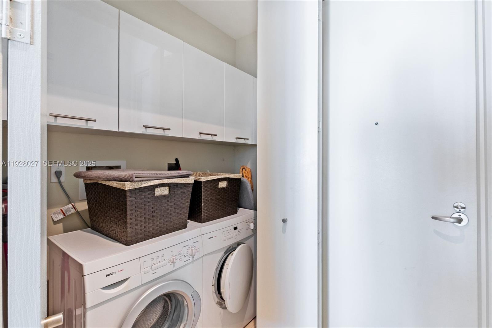 900 Brickell Key Boulevard, Unit 2002 Miami, FL 33131 - Photo 16 of 28 a view of washer and dryer with kitchen in the background