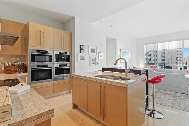 a kitchen with stainless steel appliances granite countertop a sink stove and a refrigerator