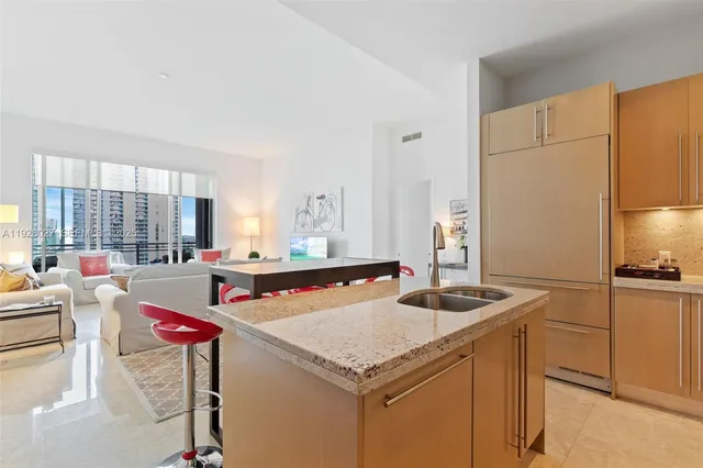 a kitchen with stainless steel appliances granite countertop a sink refrigerator and cabinets