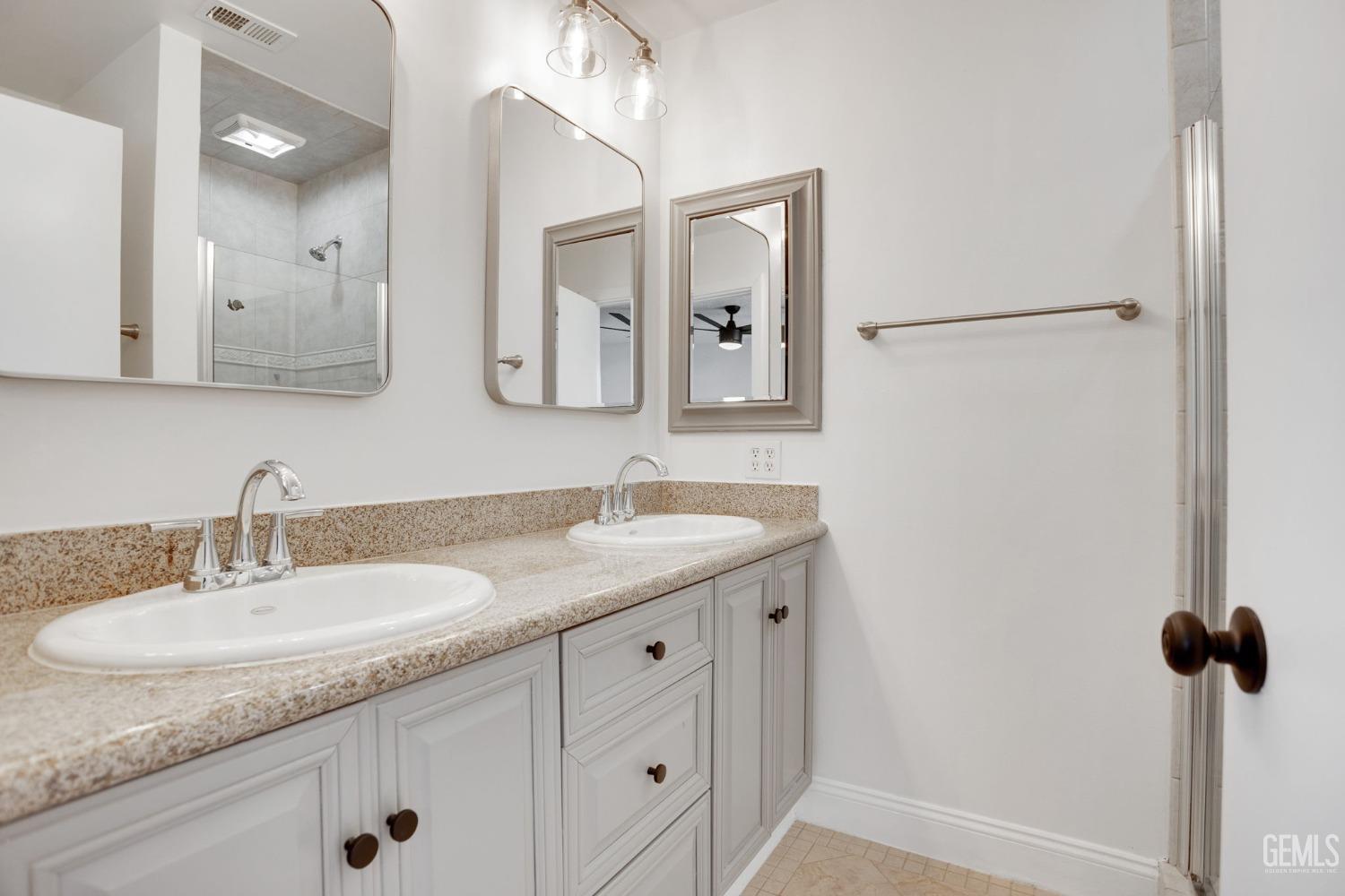 Undisclosed Address Bakersfield, CA 93312 - Photo 16 of 29 a bathroom with a granite countertop sink and a mirror
