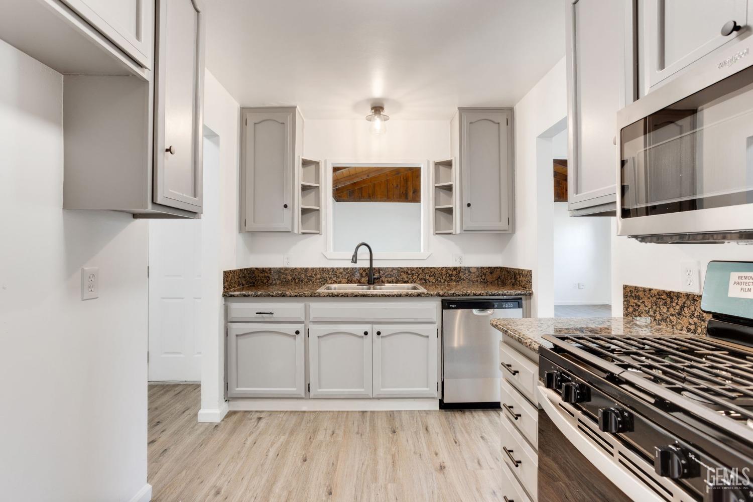 Undisclosed Address Bakersfield, CA 93312 - Photo 10 of 29 a kitchen with granite countertop a sink stove and cabinets