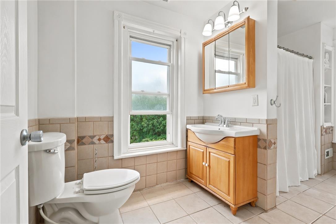 803 Spring Street Bethlehem, PA 18018 - Photo 24 of 34 A well-lit bathroom with tile flooring and a window offering a lush green view.