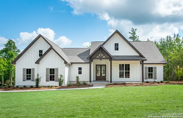 a front view of a house with a garden and yard