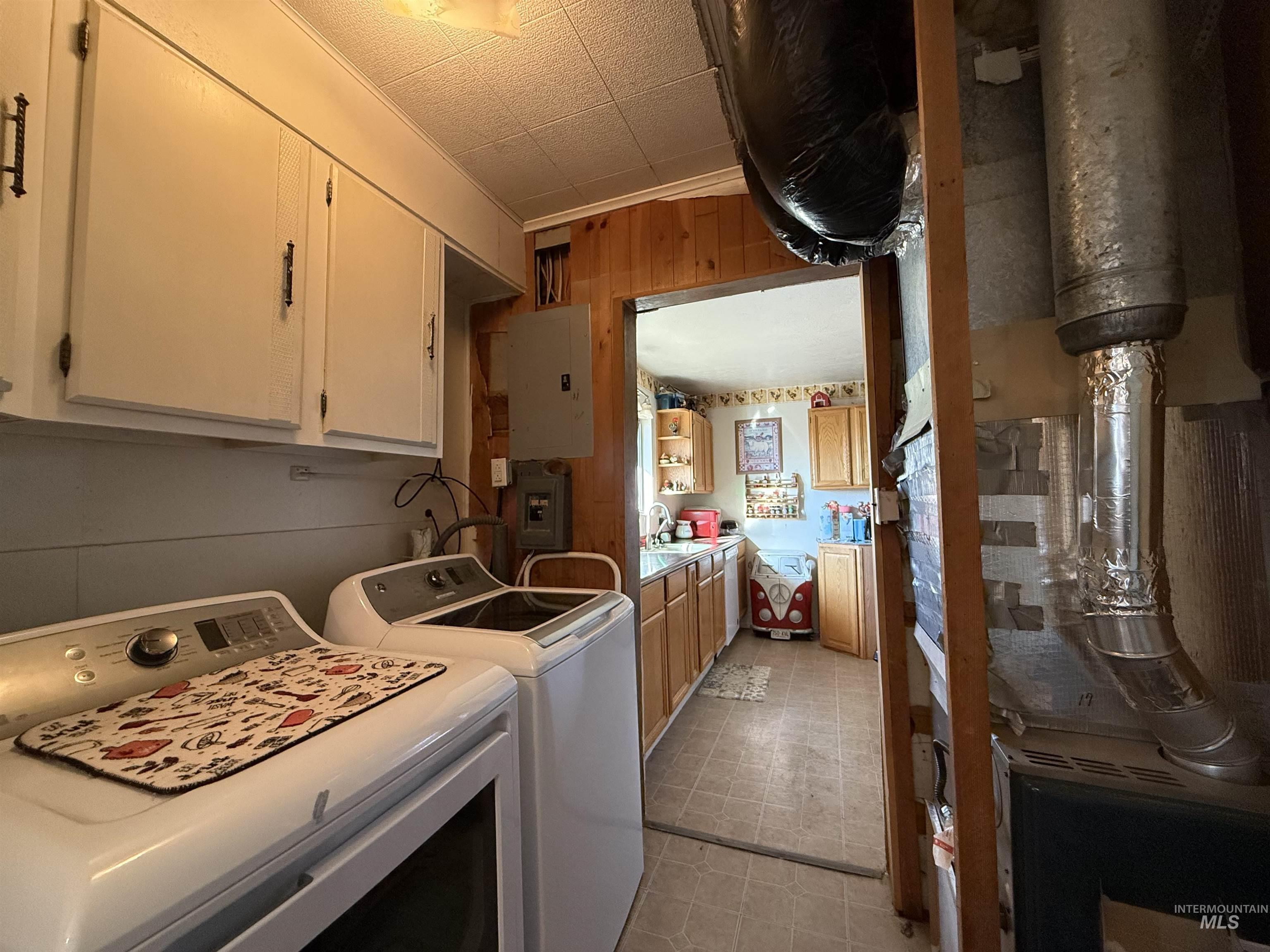 19241 West Homedale Road Caldwell, ID 83607 - Photo 27 of 35 Laundry room featuring washing machine and dryer, electric panel, light flooring, and wood walls