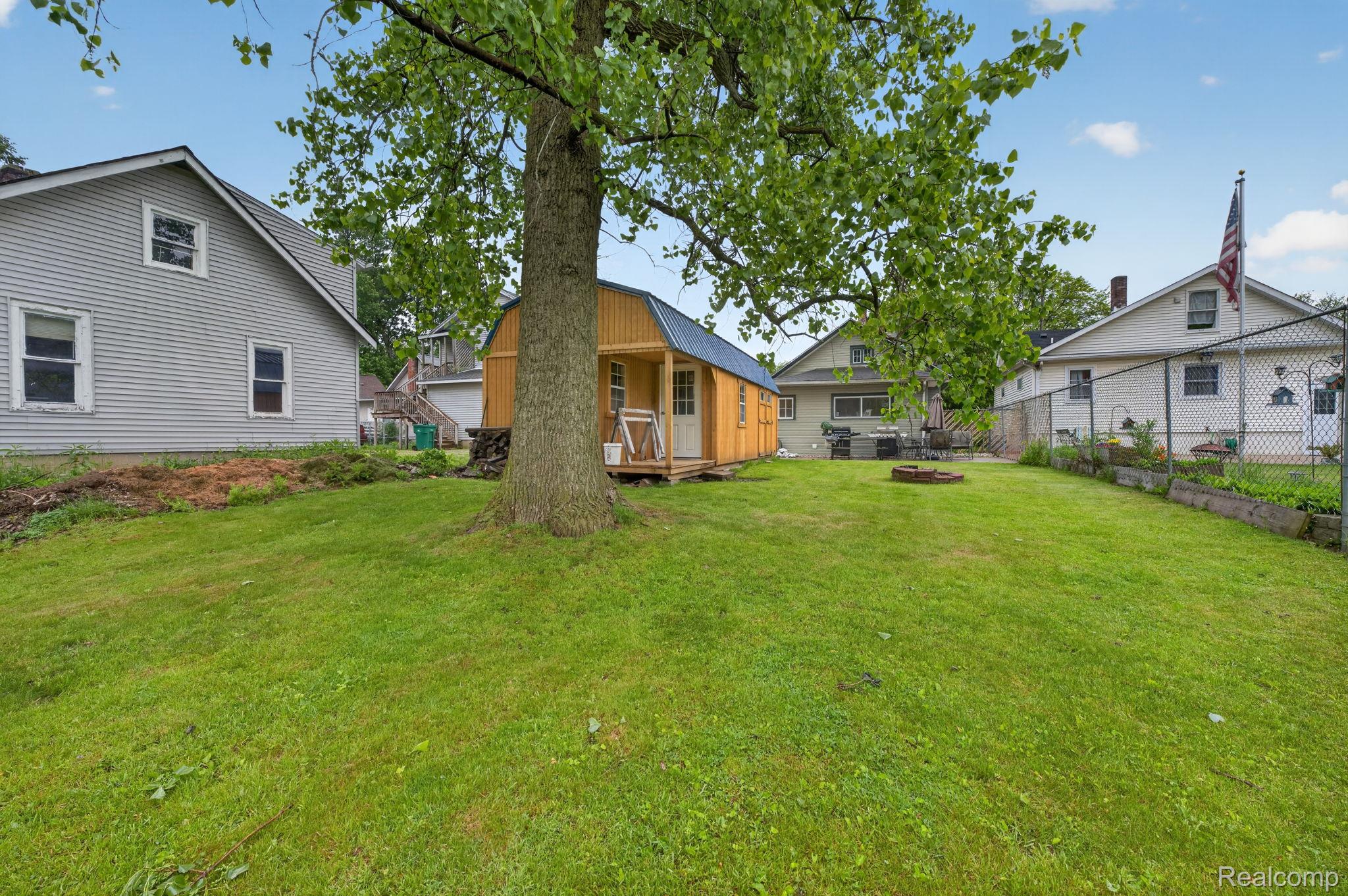 304 West Ridge Street Owosso, MI 48867 - Photo 31 of 45 Back of house with a fire pit and a wooden deck
