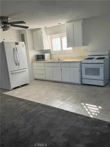 a kitchen with stainless steel appliances a stove a sink and white cabinets