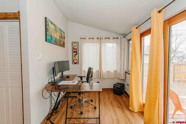 a view of a workspace with furniture and a window